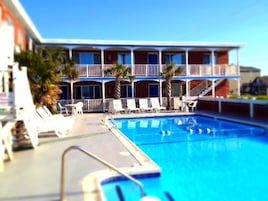 Una piscina al aire libre de temporada, sillones reclinables de piscina