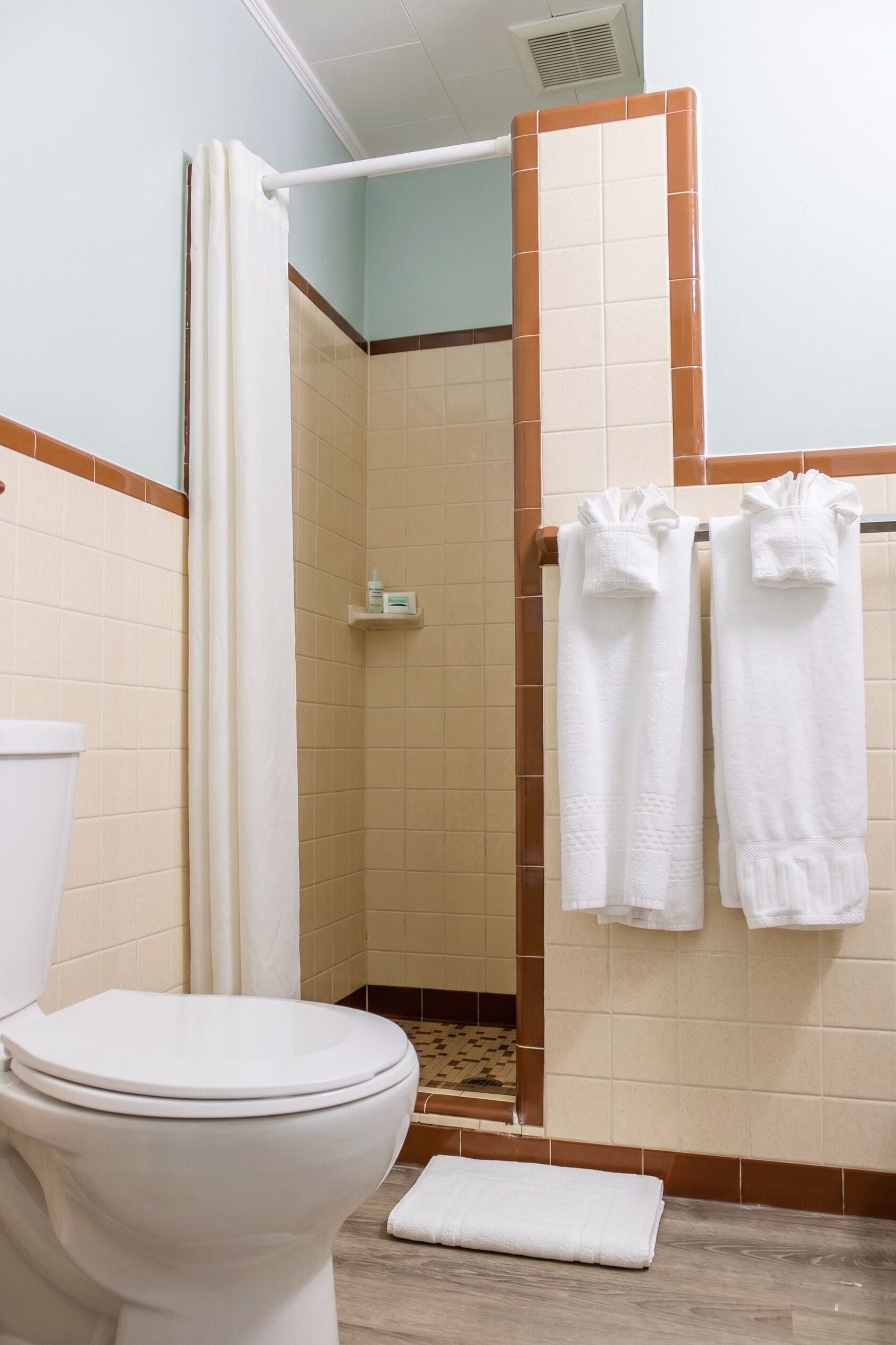 Un baño con inodoro, ducha y toallas.