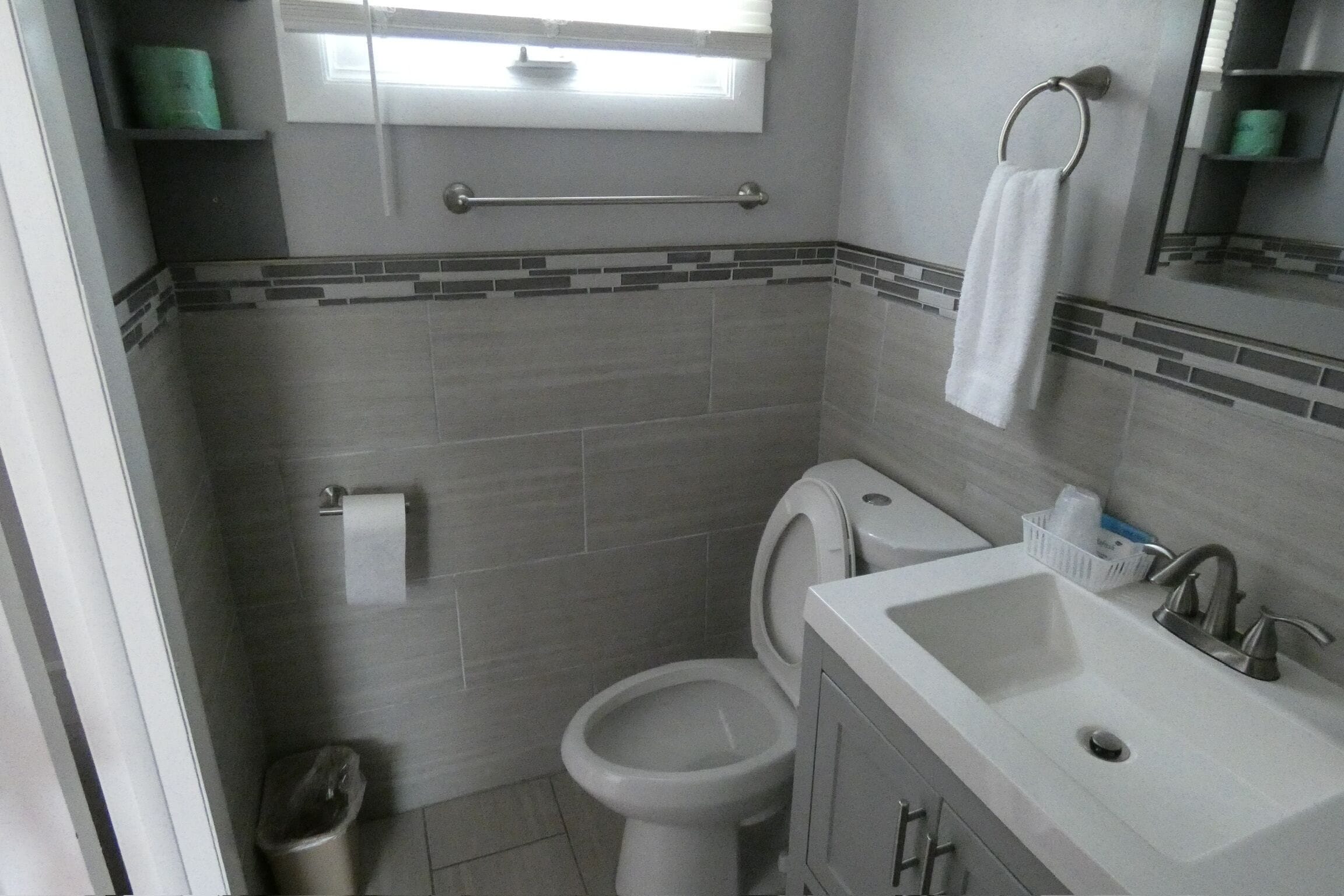 A bathroom with a toilet, sink, and towel rack.
