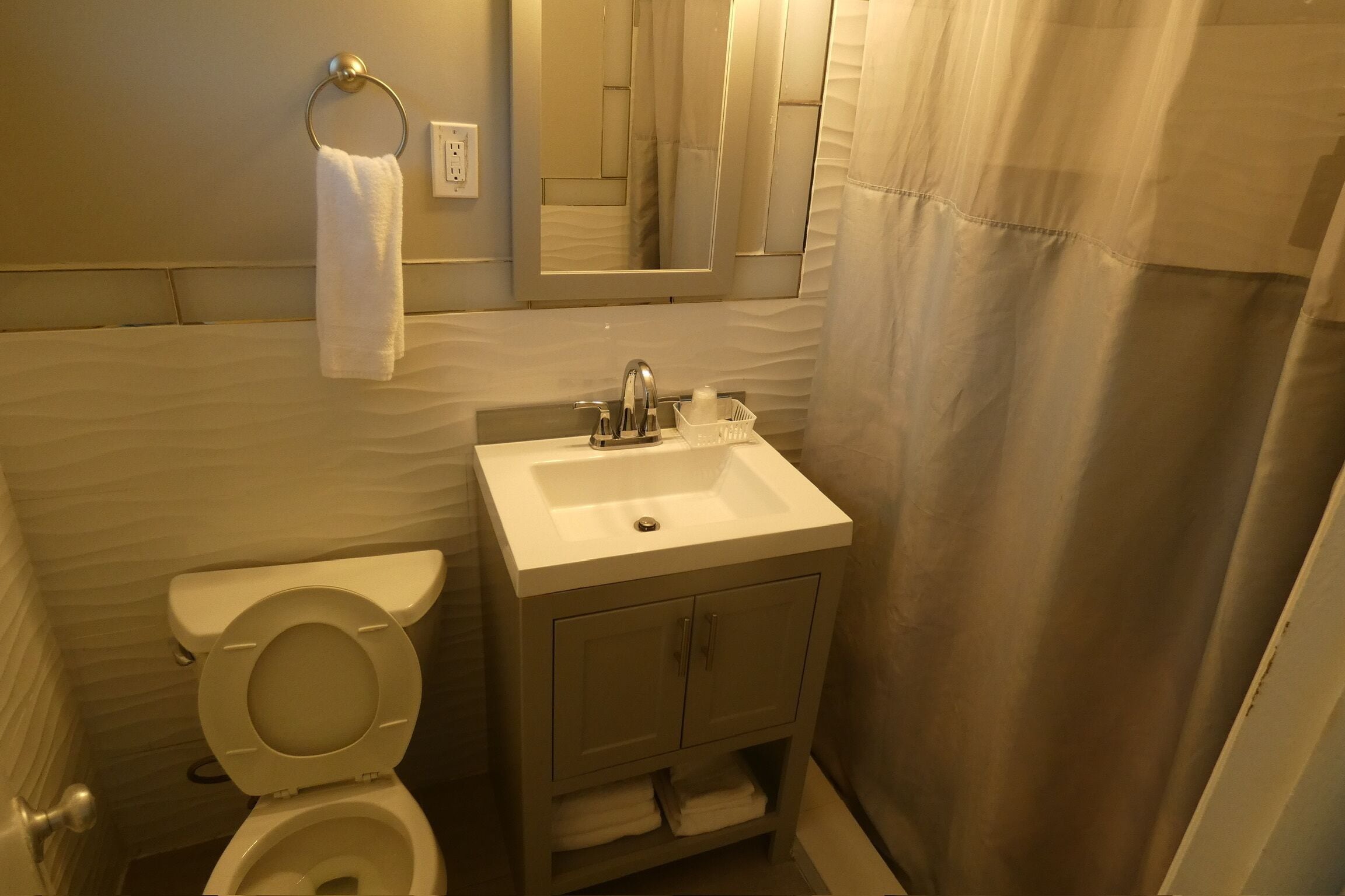 Une salle de bain avec des toilettes, un lavabo et un meuble de rangement.