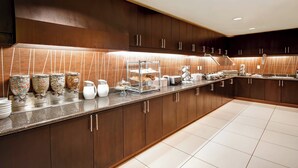 A modern kitchen with a long counter, stainless steel appliances, and a variety of food items displayed. - Residence Inn by Marriott Stillwater (Stillwater)