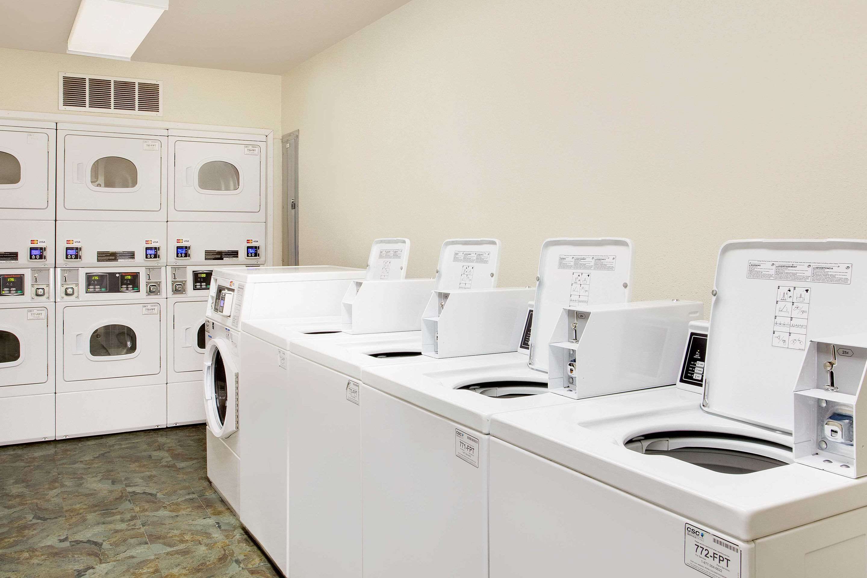 A laundry facility with multiple washing machines and dryers.