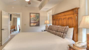 A spacious bedroom with a large bed, wooden headboard, and a ceiling fan.