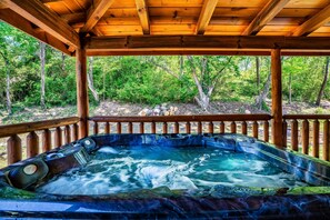 A hot tub under a wooden pergola with a forest view. - RiverStone Condo Resort & Spa (Pigeon Forge)