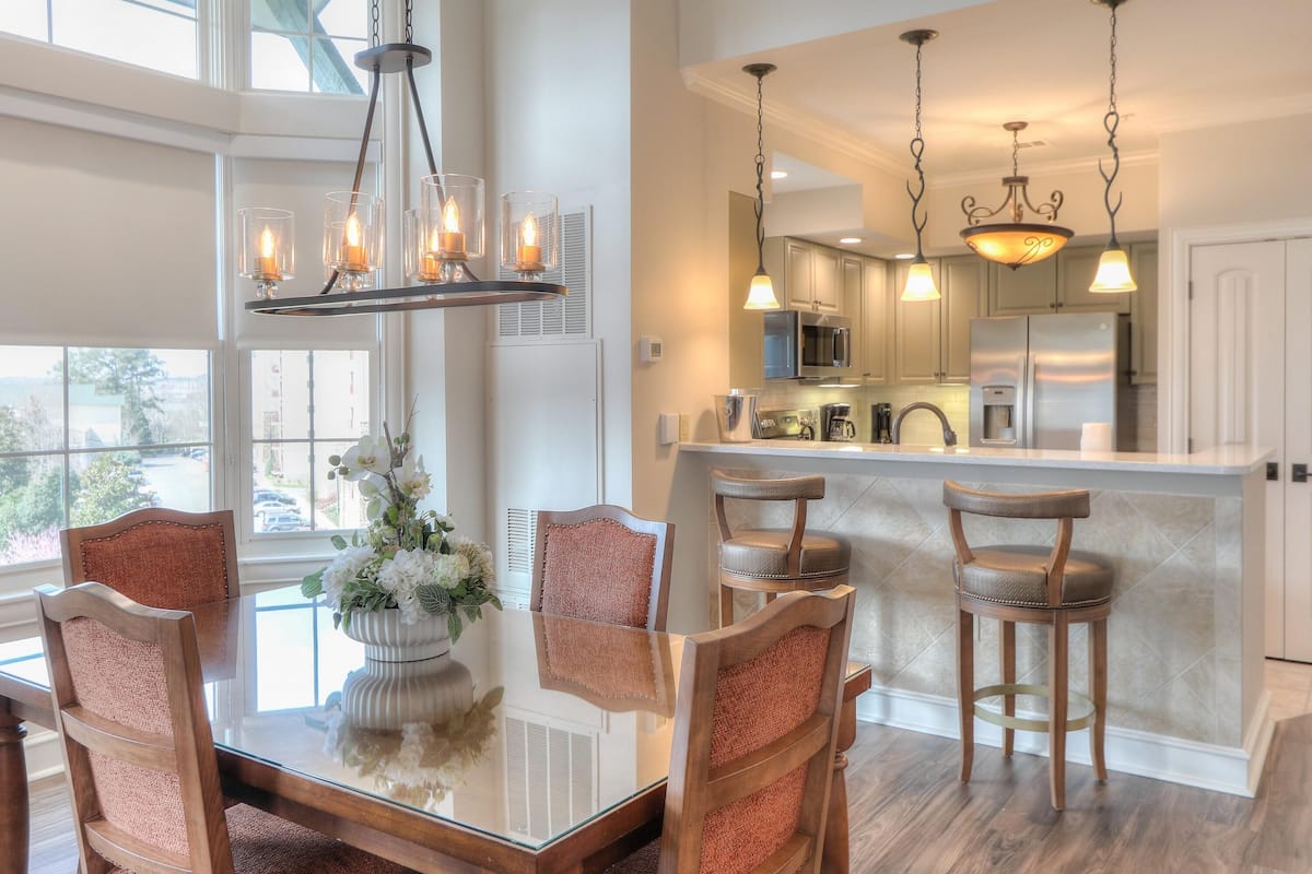 A modern kitchen with a central island, stainless steel appliances, and pendant lighting.