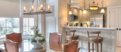 A modern kitchen with a central island, stainless steel appliances, and pendant lighting.