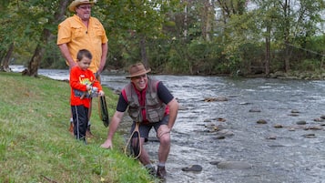 A man and a child fishing by a river.