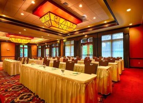 A conference room with long tables, chairs, and a large chandelier.