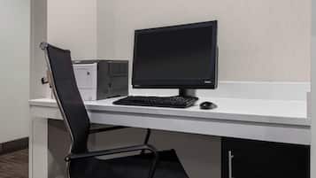 Un'area ufficio moderna con scrivania, computer, tastiera, monitor e sedia.
