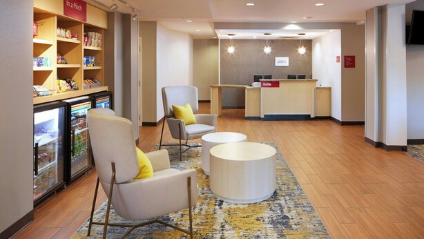 A hotel lobby with seating, a reception desk, and a refrigerated display. - TownePlace Suites by Marriott Winchester (Winchester)
