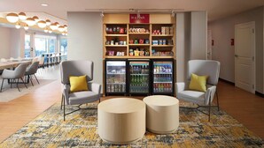 A modern lobby with two armchairs, a coffee station, and a snack bar. - TownePlace Suites by Marriott Winchester (Winchester)