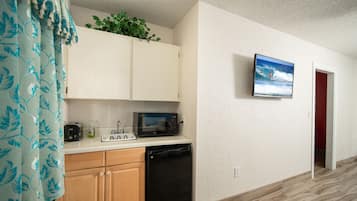 A kitchen with a microwave, dishwasher, and cabinets.