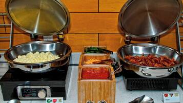 A buffet with scrambled eggs, cheese, and bacon.