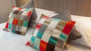 A bed with two pillows featuring a patchwork design.