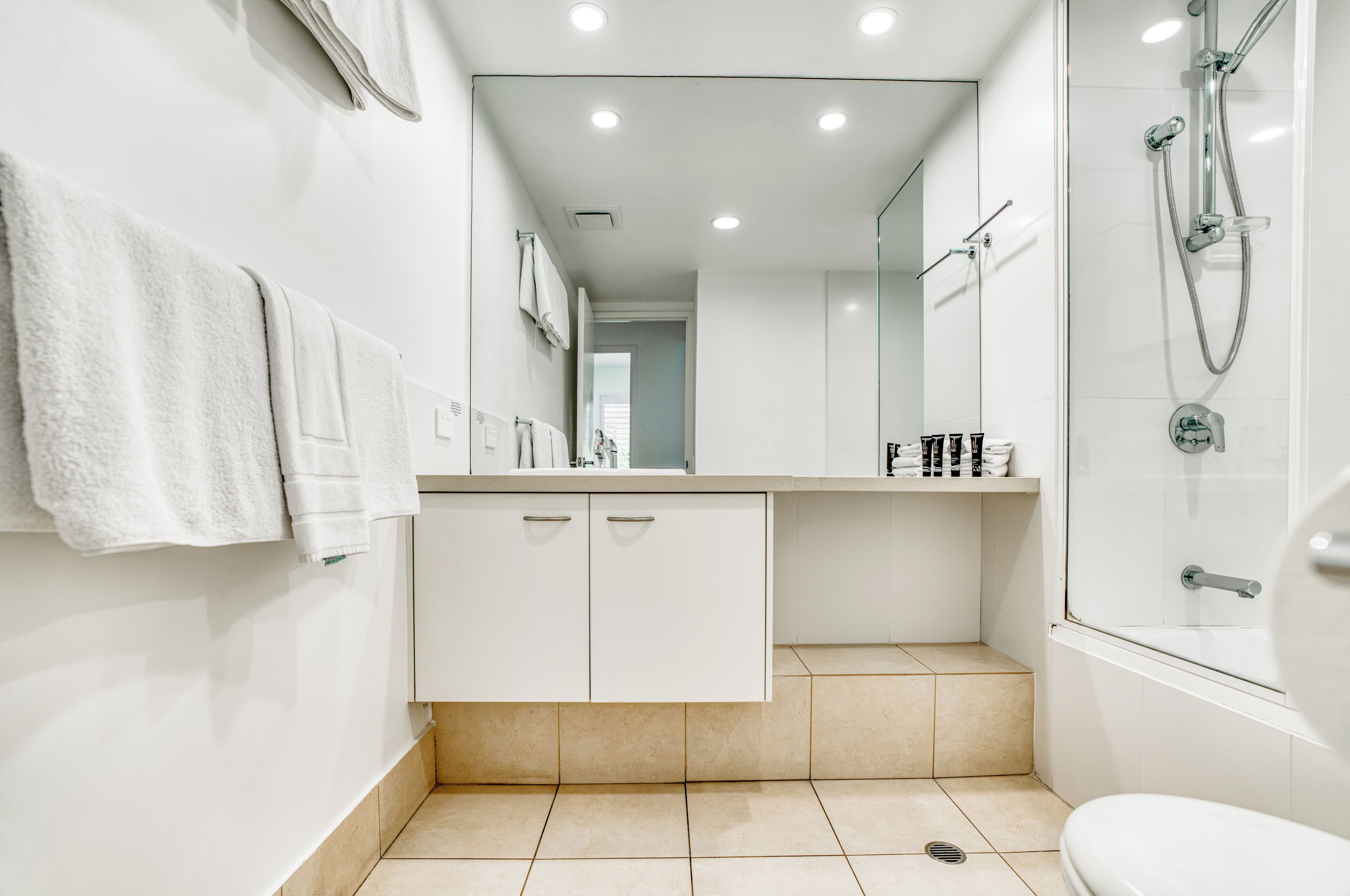 Un baño moderno con ducha, inodoro y lavamanos.