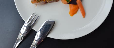 A white plate with a piece of food and a fork.