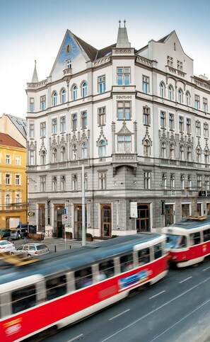 Un edificio histórico con detalles arquitectónicos ornamentales, incluyendo una imponente torre del reloj y numerosas ventanas.