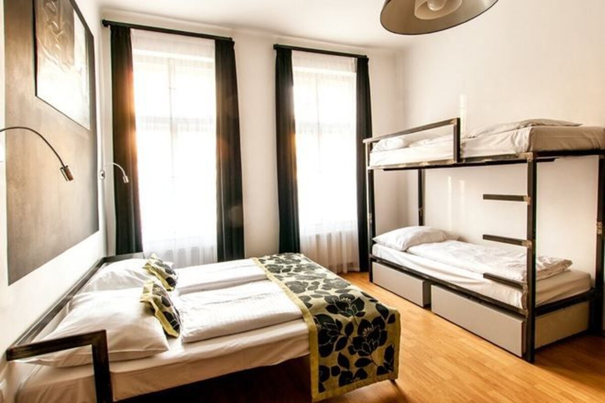 A room with a single bed, a bunk bed, and a desk.
