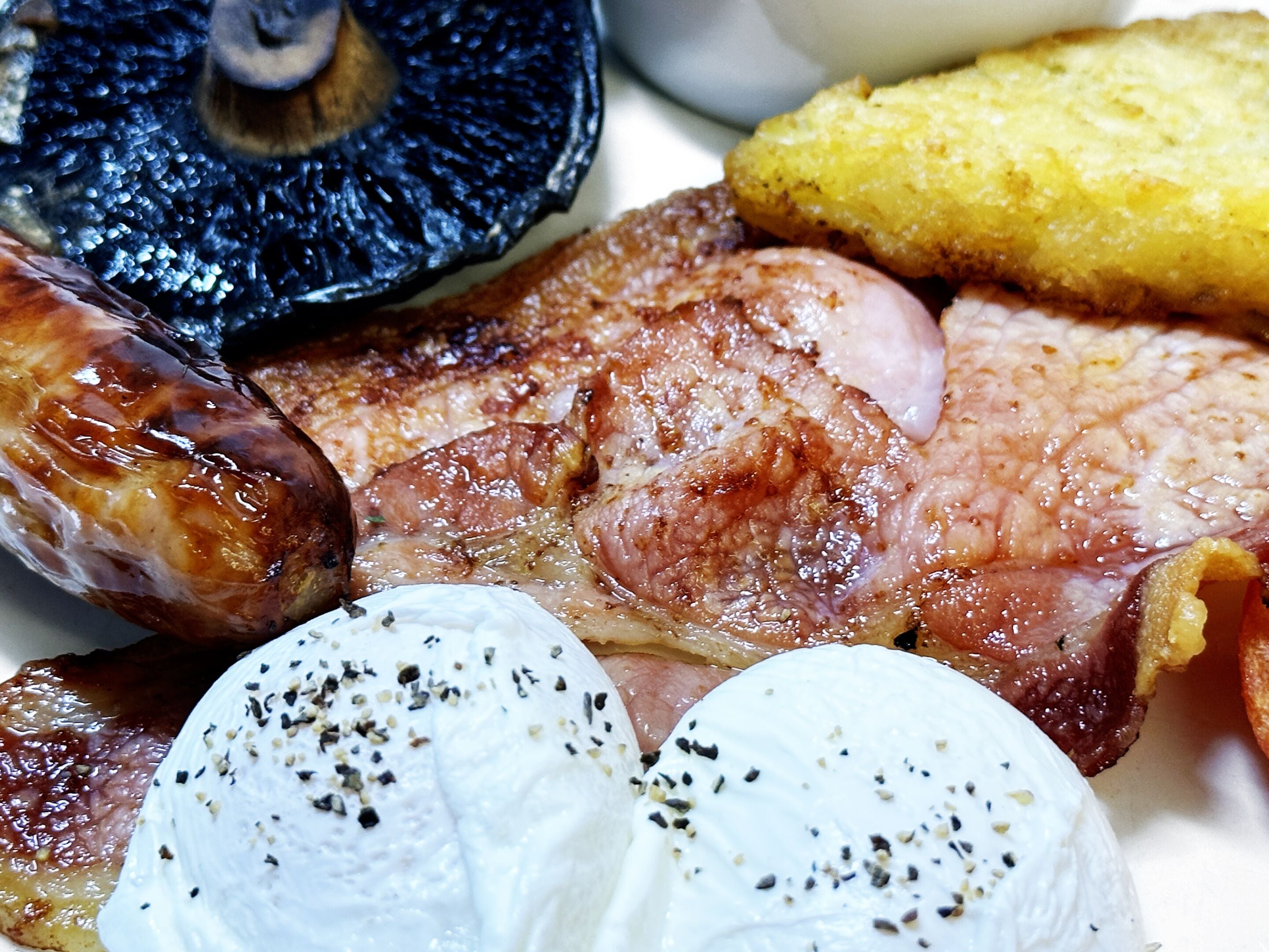 A plate with grilled meat, sausages, and boiled eggs.