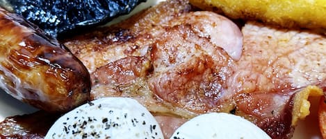 A plate with grilled meat, sausages, and boiled eggs.