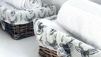 A set of neatly folded towels with deer patterns, placed on a white surface.