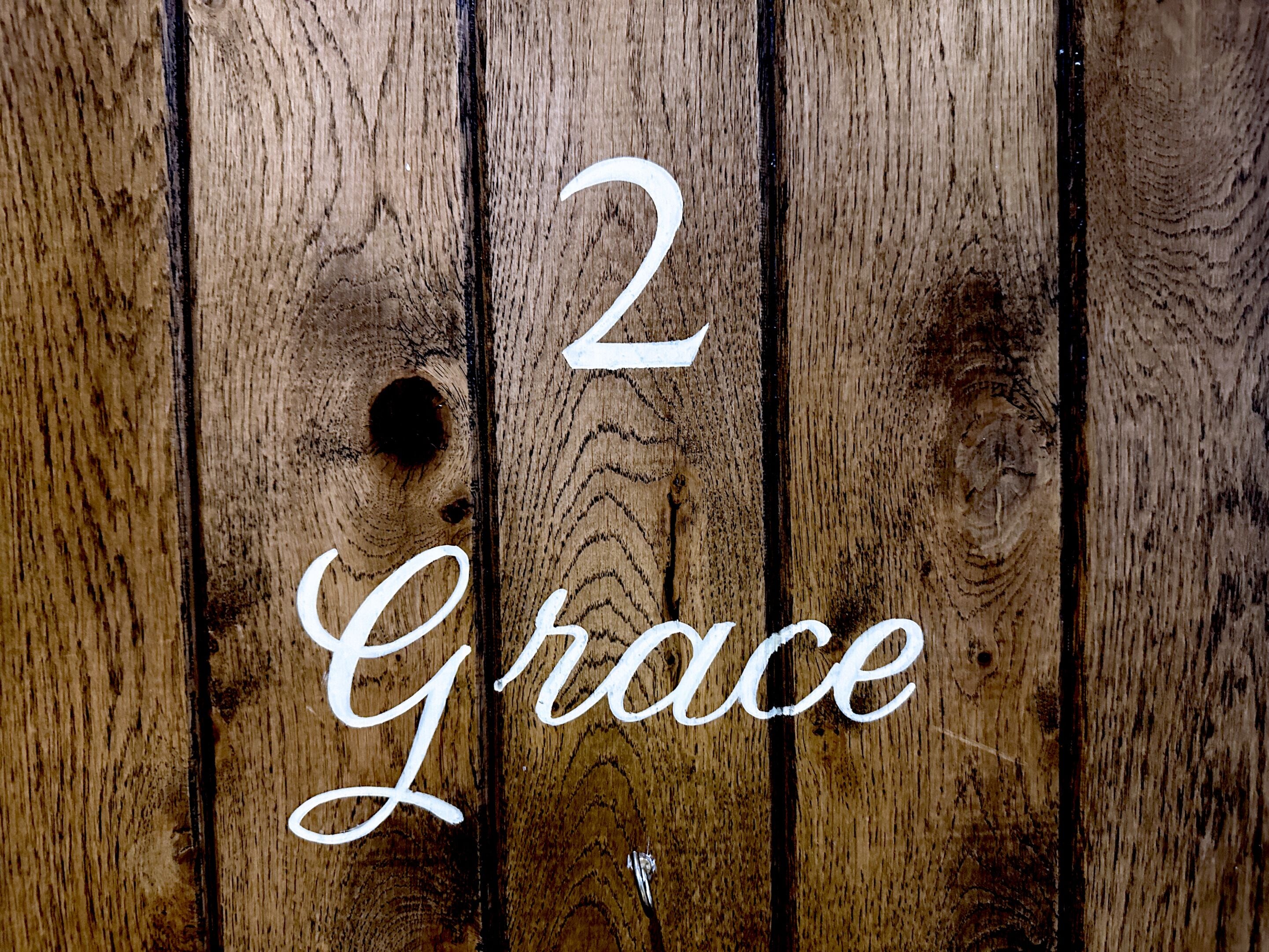 A wooden surface with the number "2" and the word "Grace" written on it.