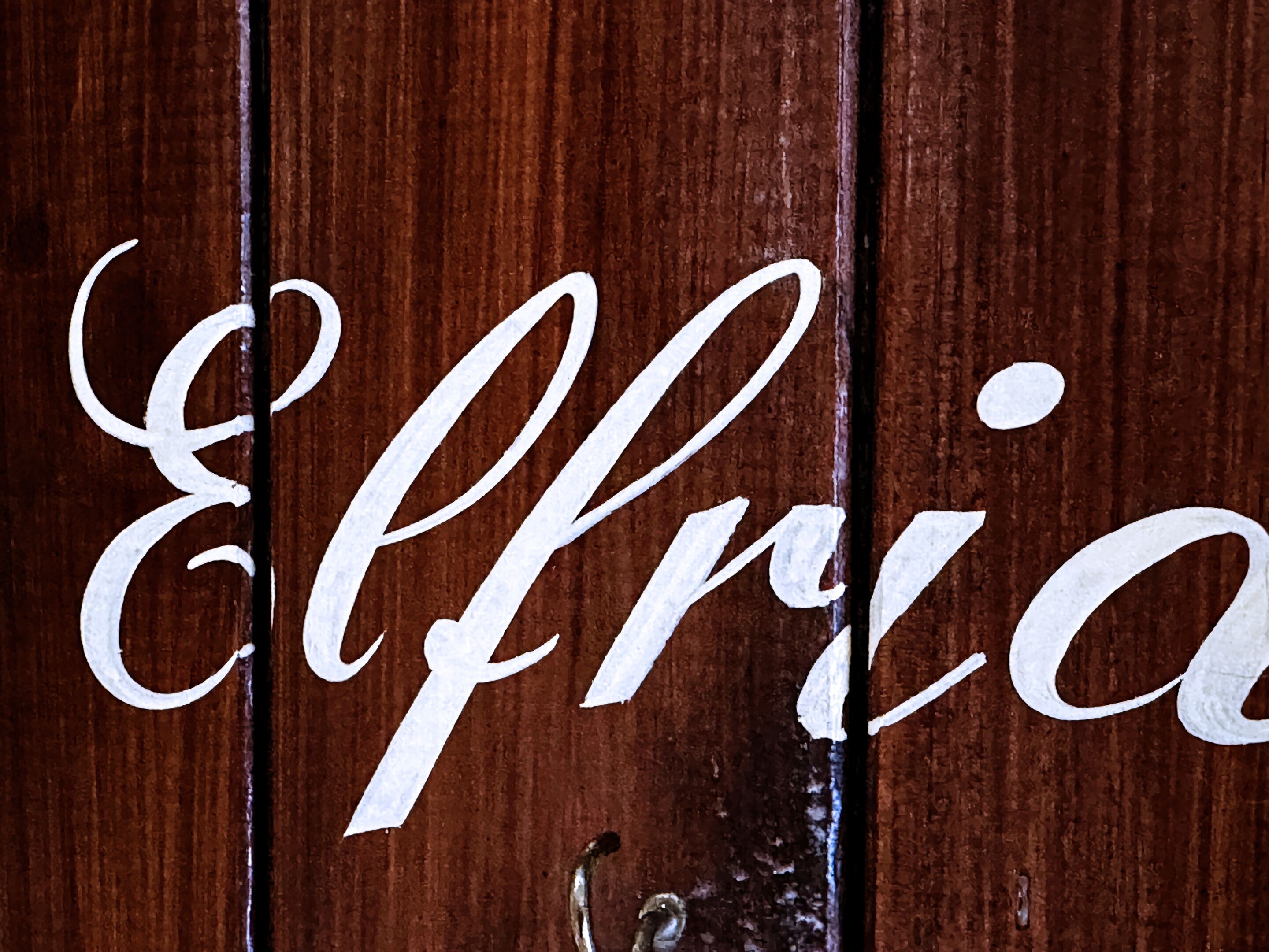 Una superficie de madera con la palabra "Elleria" escrita con caligrafía.