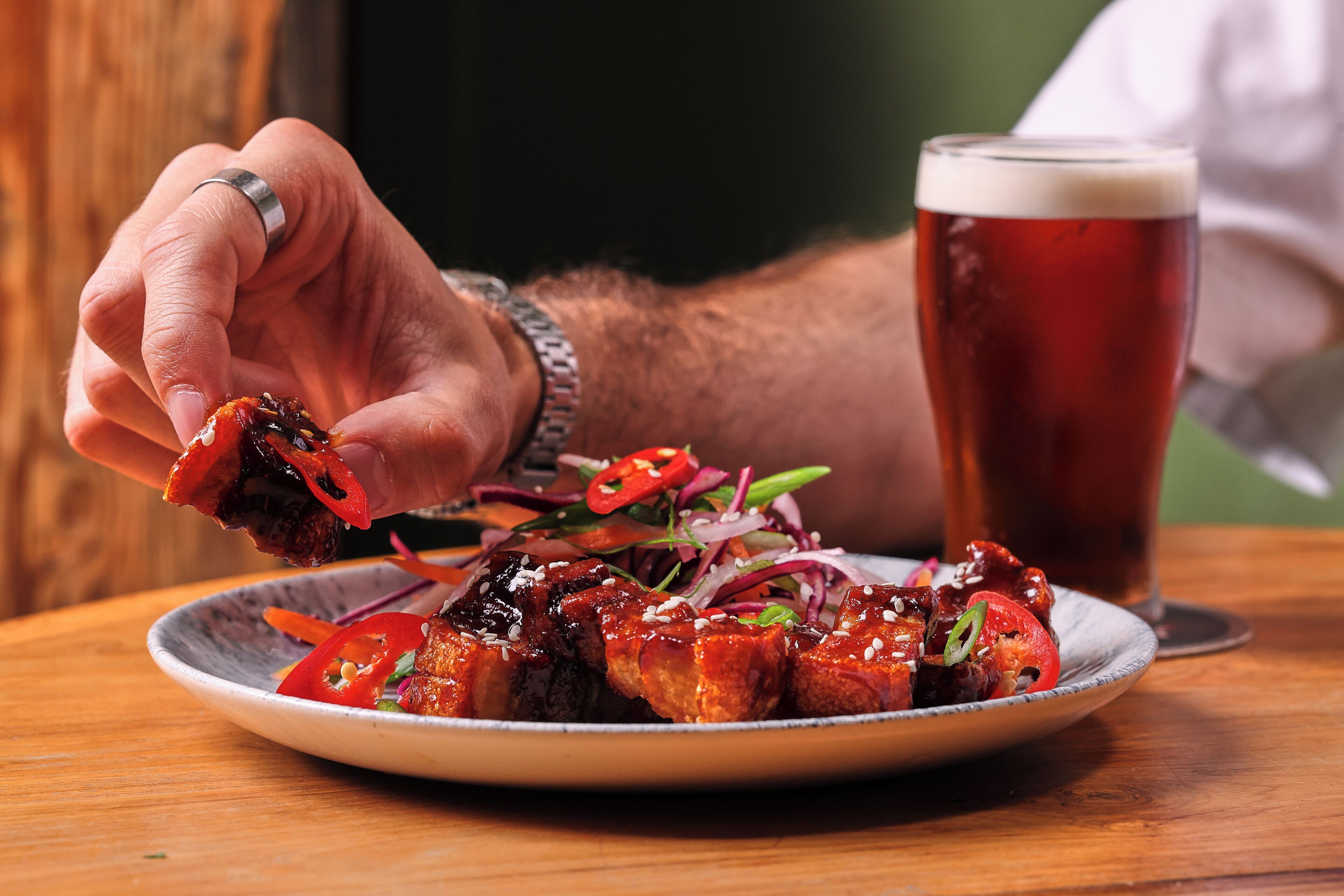 A plate of food with a glass of beer beside it.