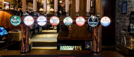 A bar with multiple beer taps, including brands like Carlsberg and Guinness.