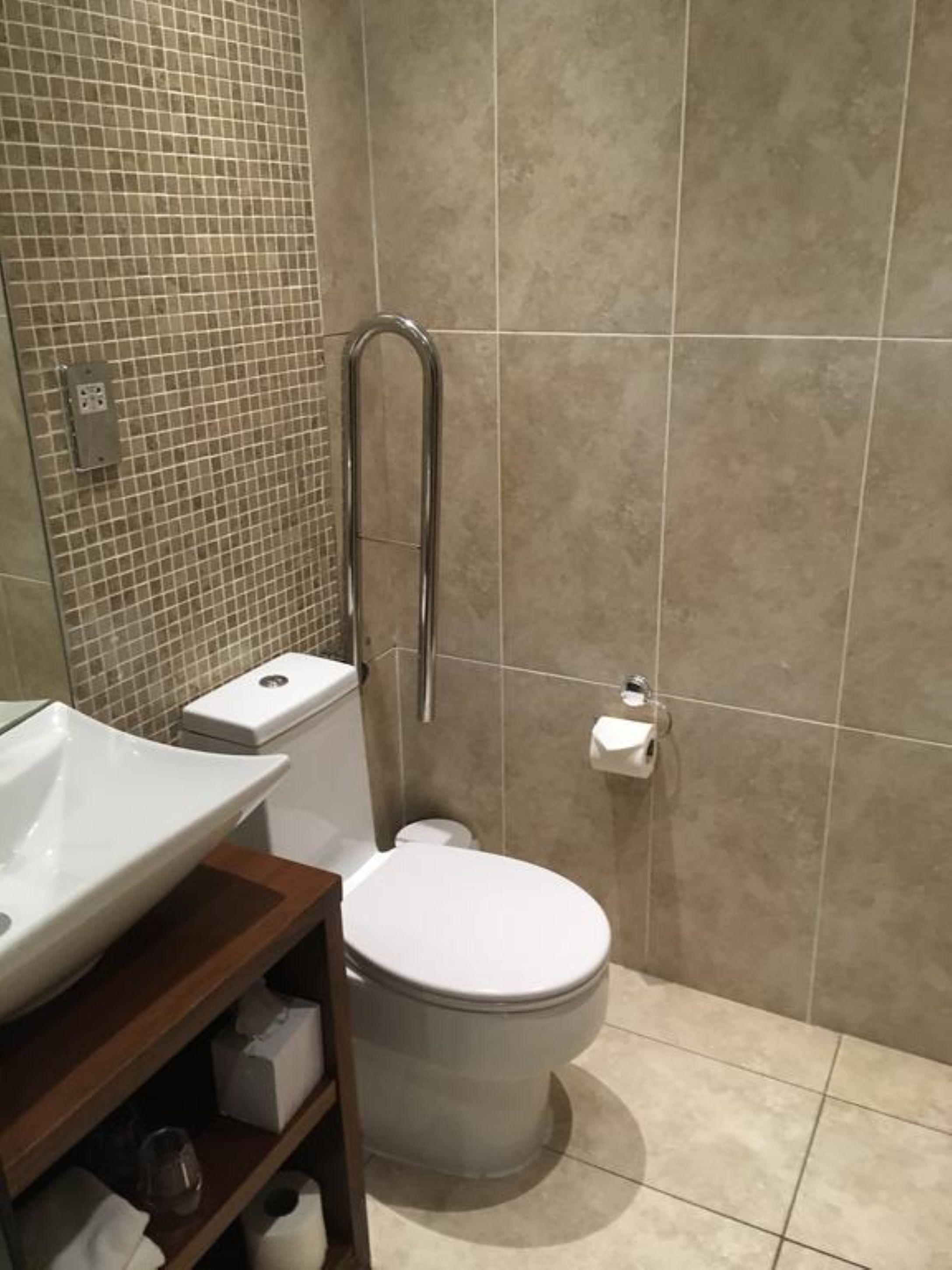 A bathroom with a white toilet, a white sink, and a shower area.