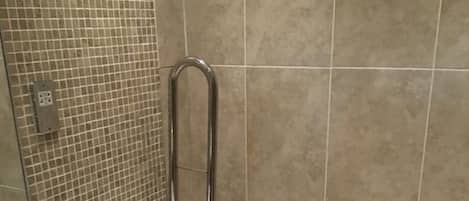 A bathroom with a white toilet, a white sink, and a shower area.