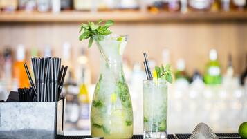 Um bar com duas bebidas, um coqueteleira e uma garrafa de licor.