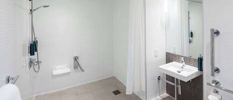 A modern bathroom with a glass-enclosed shower, a white sink, and a mirror.