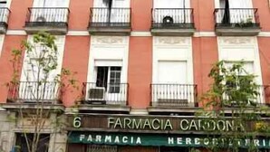 A multi-story building with balconies and a storefront labeled "FARMACIA CANDONAS". - Hostal Santo Domingo (Madrid)