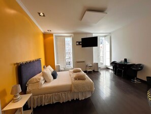 A hotel room with a bed, a desk, a chair, a TV, and a window. - Hostal Santo Domingo (Madrid)