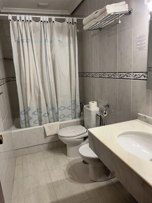 Bañera con ducha, artículos de tocador de diseñador, secador de pelo