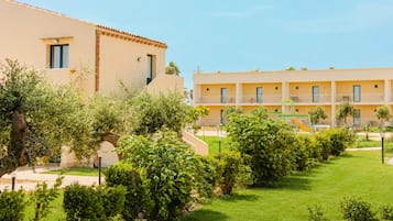 Ein Hotel mit Innenhof, inklusive Spielplatz und üppiger Bepflanzung.