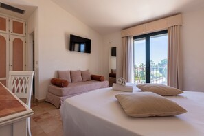 A hotel room with a bed, a sofa, a TV, and a balcony with a view. - Delfino Beach Hotel (Marsala)