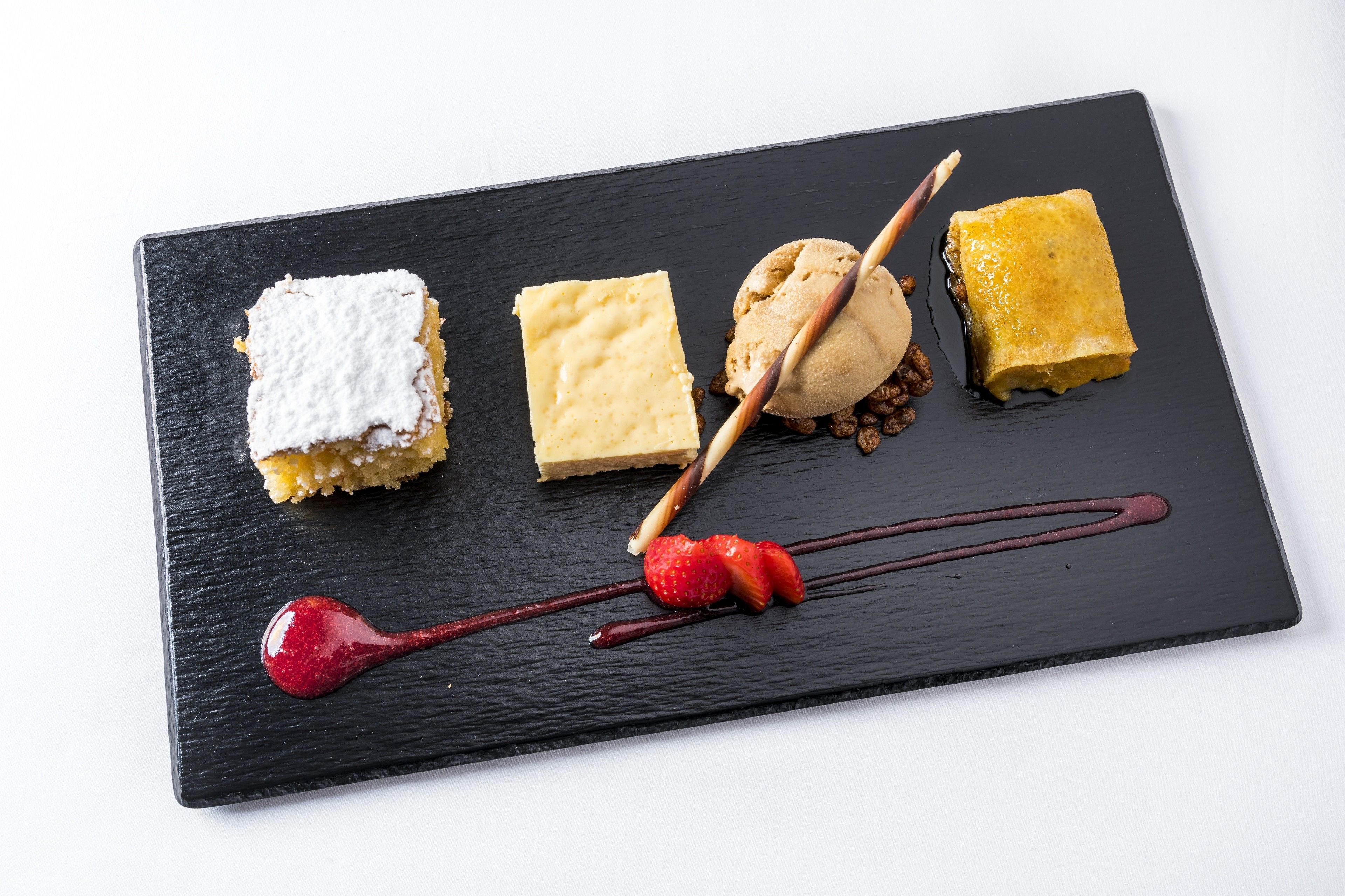 A dessert plate with various sweets and a chocolate drizzle.