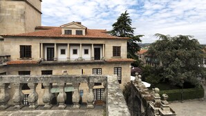 A historic building with a tiled roof, large windows, and a stone facade.