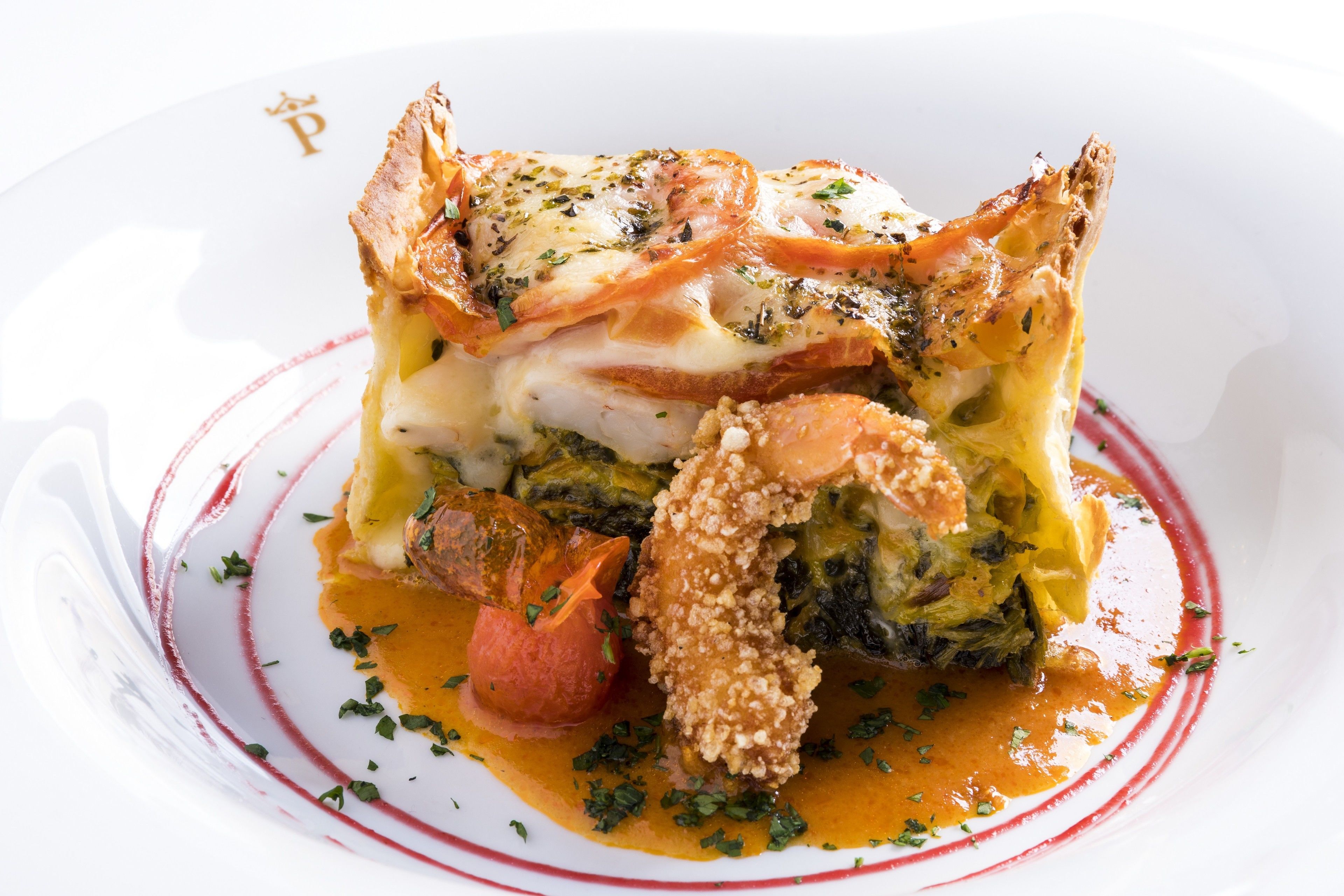 A dish with a golden-brown crust, a creamy sauce, and a garnish of green herbs.