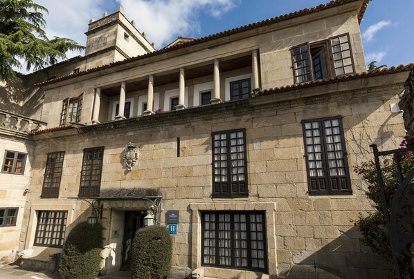 A historic building with a symmetrical facade, large windows, and a central entrance.