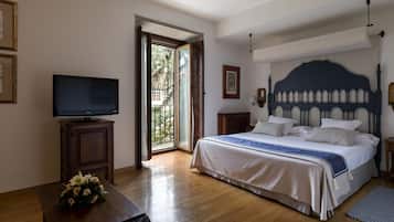 Un dormitorio con cama, televisión, escritorio y ventana.