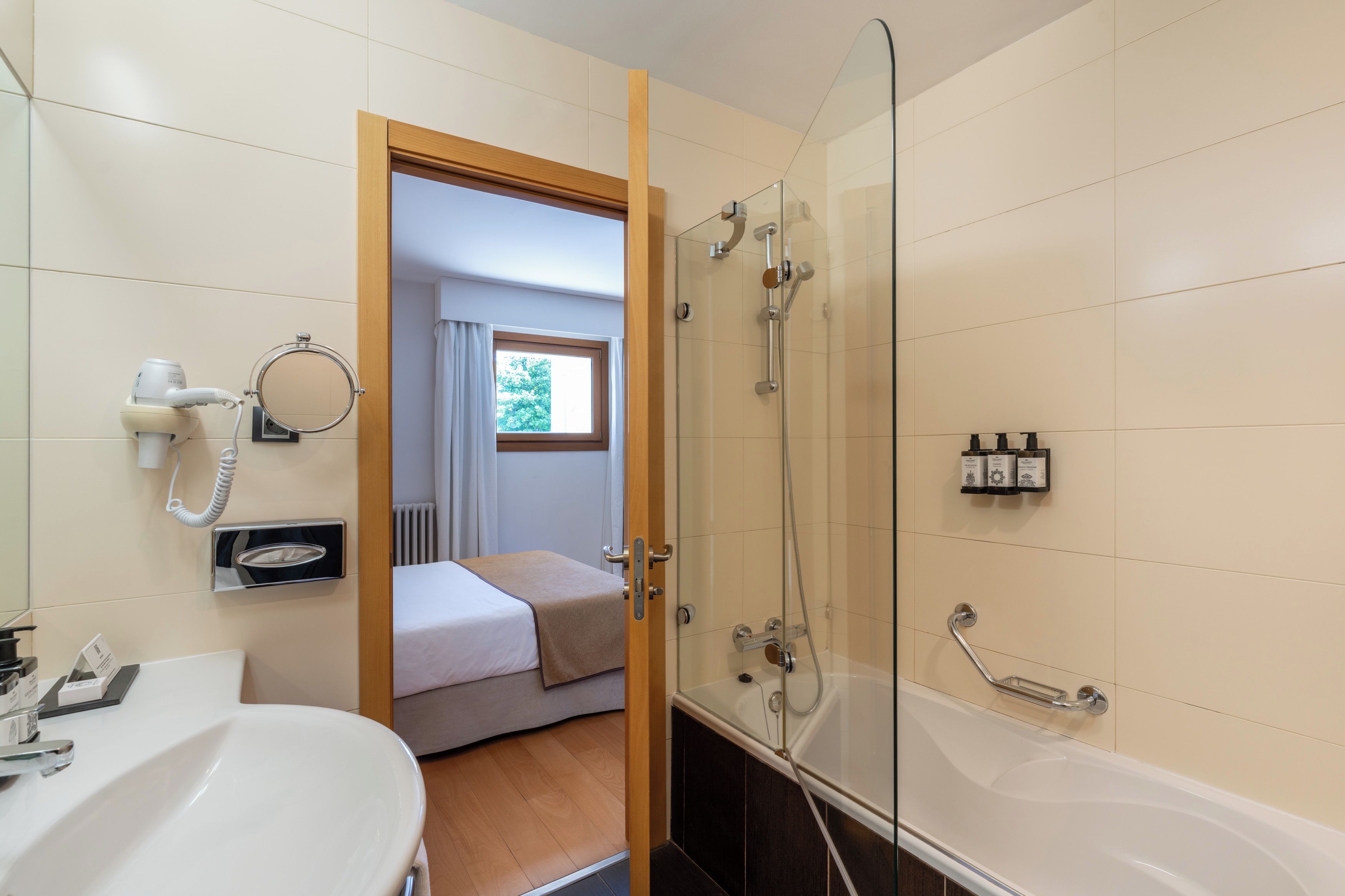 A hotel bathroom with a bathtub, a shower, and a toilet.