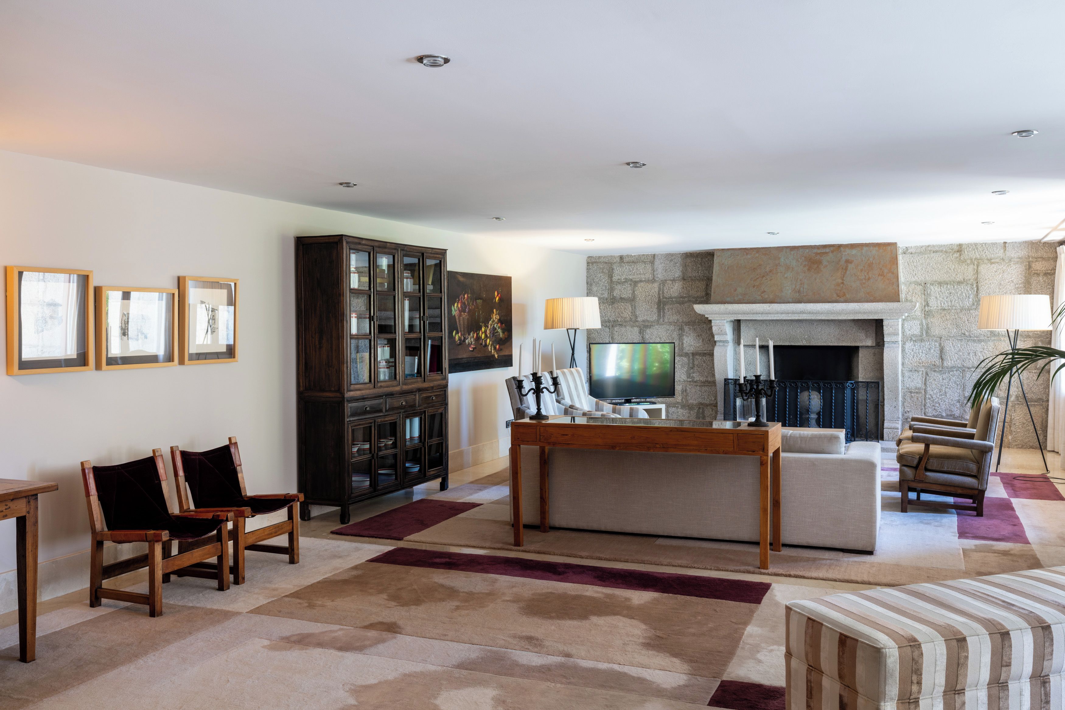 Una sala de estar con chimenea, televisor y aparador.