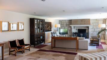 Una sala de estar con chimenea, televisor y aparador.