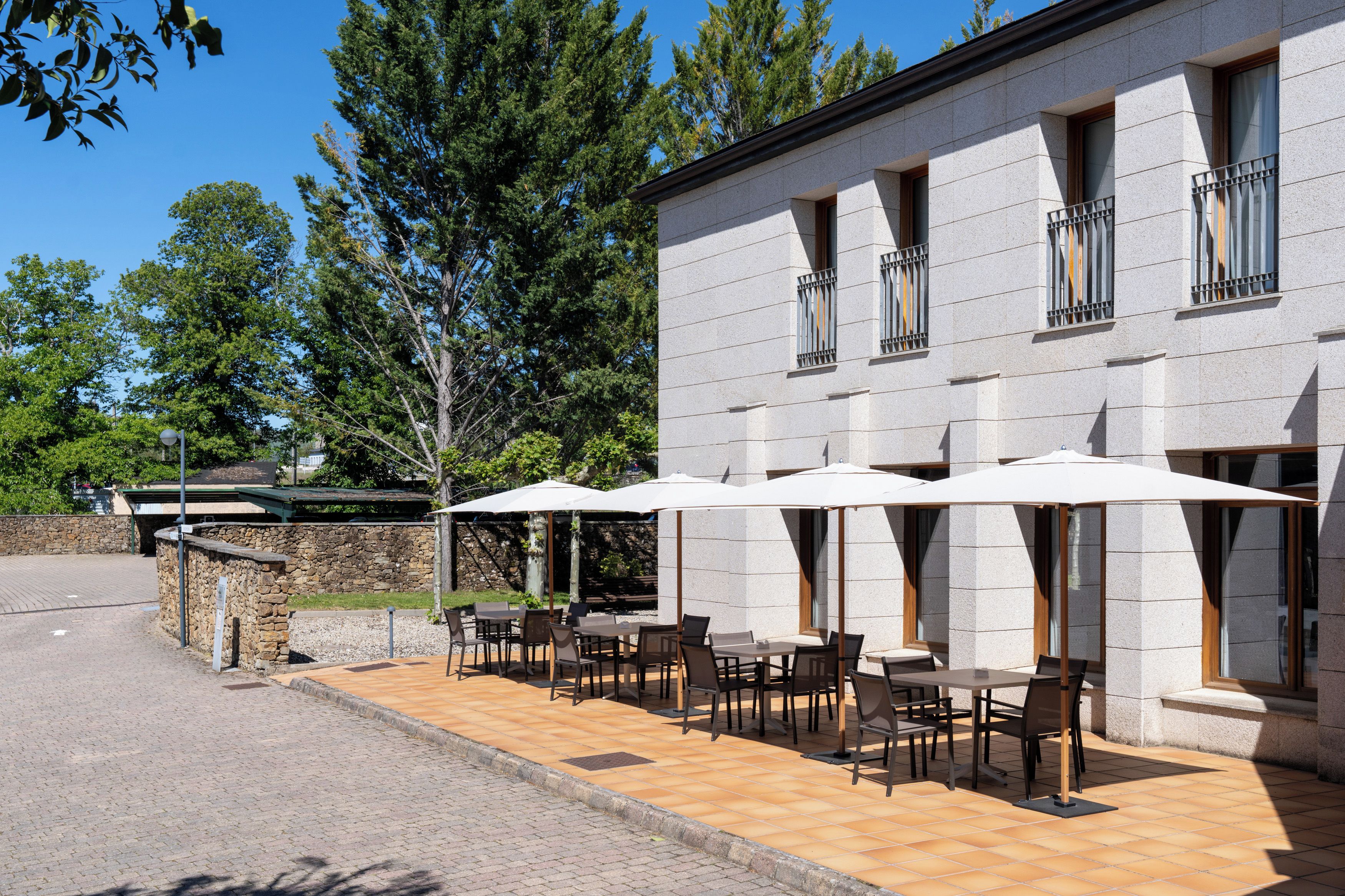 Un edificio con terraza y una pared de piedra.