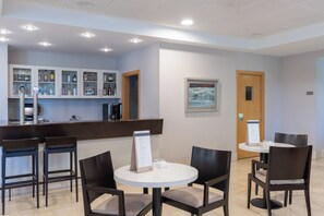A hotel lobby with a reception desk, bar area, and seating arrangement.