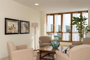 A living room with a sofa set, a coffee table, a floor lamp, and a large window with curtains. - Parador de Puebla de Sanabria (Puebla de Sanabria)