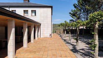 Un edificio con un patio cubierto, columnas de piedra y un camino empedrado.